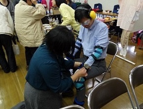 写真：高齢者の疑似体験をするための器具を装着する様子です