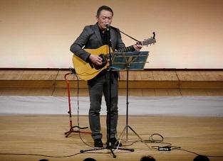 写真：沙羅利男さんのギター弾き語りの様子