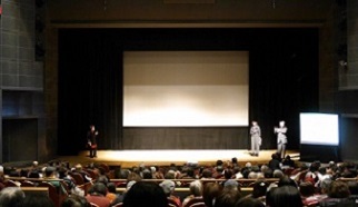 写真：舞台で映画の感想を話し合う講師の中島さんとeコールてんぱくメンバー