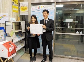 写真：オリジナル婚姻届を持つ区長とデザインをした職員