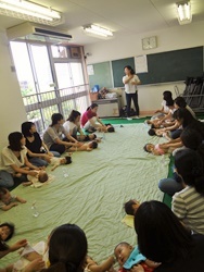 写真：乳児と母親たちが輪になって参加する様子