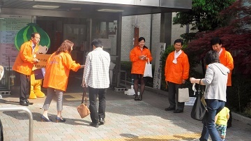 写真：区役所の玄関で来庁者を出迎えるかぼっちとスタッフ