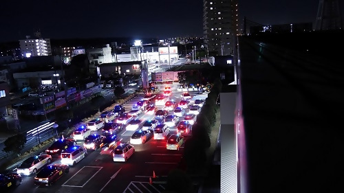 写真：駐車場から出発する区内の青色防犯パトロール車両の列