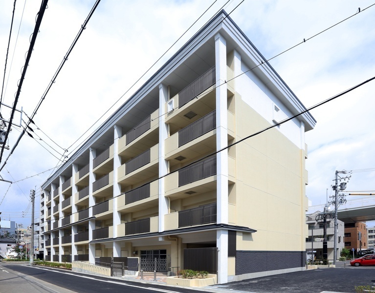 写真：道路に面する南面バルコニー側の東南方向からの俯瞰的外観。