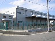 写真:2階建て建物の外観、隣接してやや小ぶりな2階建て事務所棟が建っている