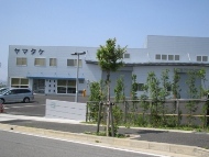 写真:青空を背景とした2階建て建物の外観2