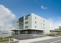 写真:青空を背景とした4階建て建物の外観