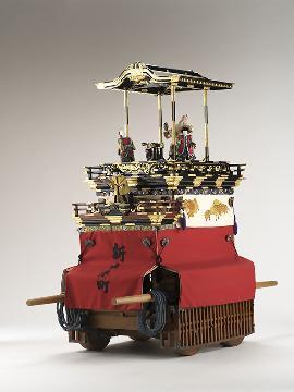 写真:人形を上に載せ、新出来町とかかれた赤い幕をつけた山車