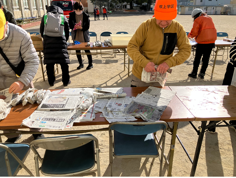 写真:新聞紙でお芋をまく