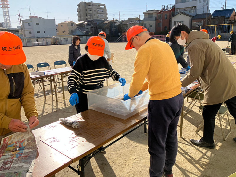 写真:新聞紙に水分を含ませる作業