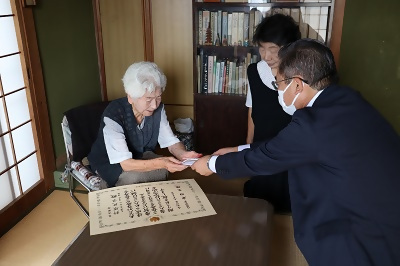 写真：針原さんにお祝い品と敬老金を贈呈する区長