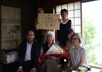 写真：針原さんを囲んで記念写真を撮る様子