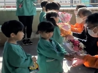 写真：園児からプレゼントをもらう区長