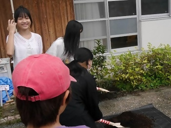 「キンモクセイ」の苗木に土を被せる子どもたちの写真