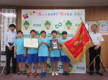 写真：大会優勝旗とともに、メンバーの皆さんと記念撮影