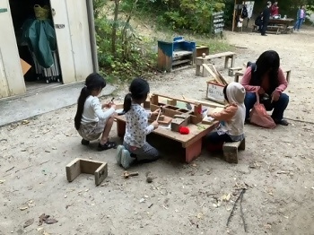 木で工作をして遊ぶ子どもたちの写真