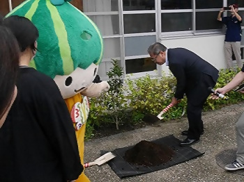 「キンモクセイ」の苗木に土を被せる区長の写真