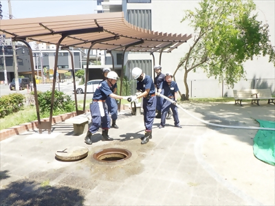 写真:水に満たされたホースを持ちながら管そうの操作方法を確認しています。 【消防団の記録】亀島消防団 2024年7月7日