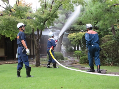 写真:草木に放水しています 【消防団の記録】2024年7月26日 中村公園夏まつり納涼花火観賞会