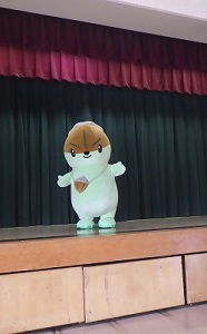 守山区役所講堂の舞台上に立つモリスちゃんの写真