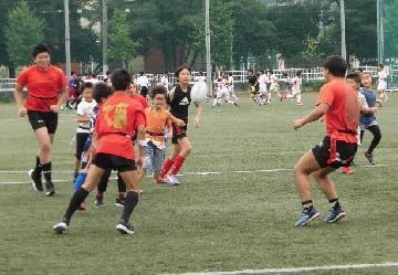 写真：子供たちと走るラグビーの様子です。