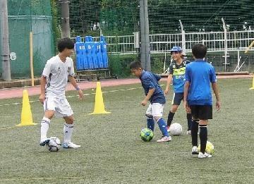 写真：子供たちと走るサッカーの様子です。