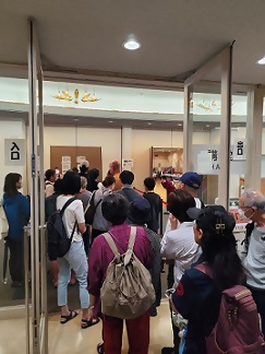 写真:バザー会場で混み合う入口