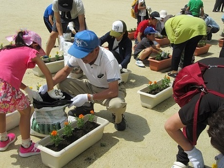 写真：子どもたちと花を植えて、快適なまちづくりを行っています。