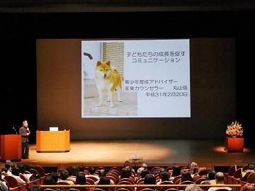 写真:青少年育成区民大会のステージで講演を行う講師