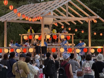 写真：やぐらの上で踊る人々と見物する人々