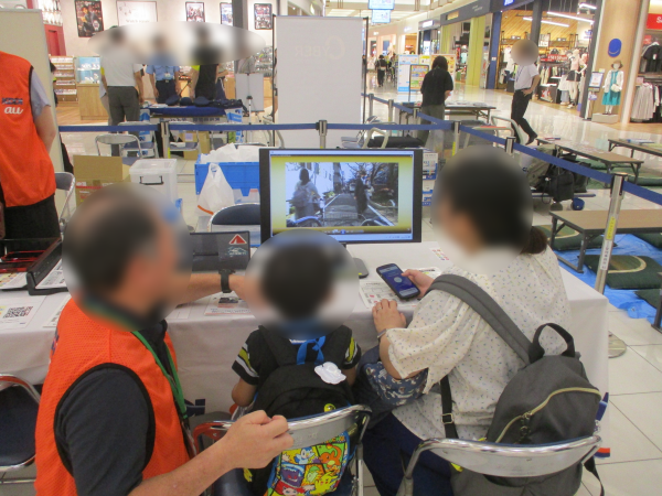 写真：KDDI「ながらスマホ」リスクシミュレーター体験のブースの様子です。