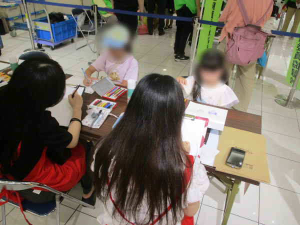 写真：似顔絵プレゼントのブースの様子です。