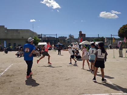 写真:障害物リレーで、タスキを渡す瞬間