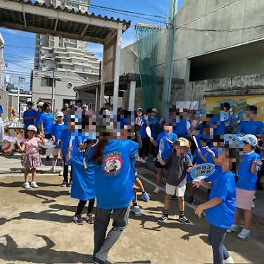 写真:揃いの青いうちわ「熱田区旗屋」とTシャツ「熱田区旗屋 BUKENEKO 2025 名古屋まつり」