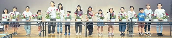 写真：完成した作品を前に集合している様子（1回目）の画像