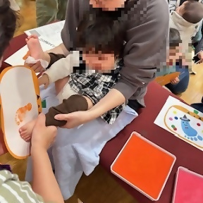 写真：両足おとなしく足形を取られる子