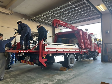 2輸送車の荷台に荷物を載せる写真