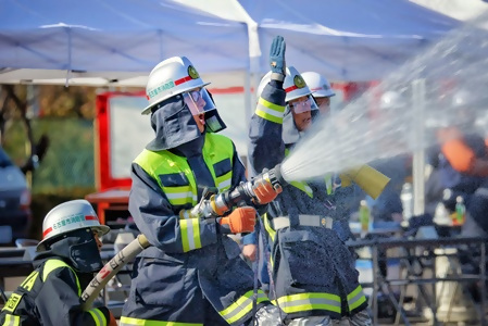 連携訓練（男性消防団員がホースをもって放水をしている様子）