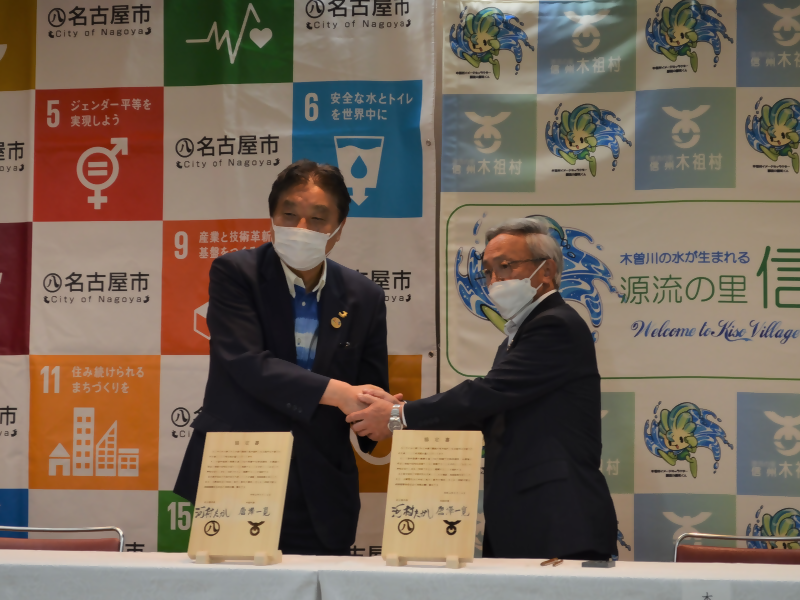 協定式での名古屋市長・木祖村長の写真