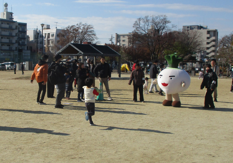 大根をもって走るこどもの画像です