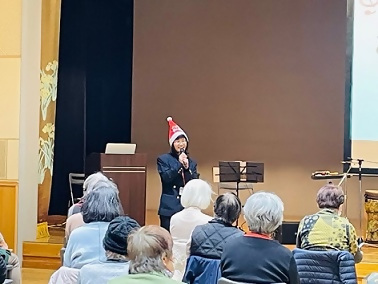 画像：サンタ帽子をかぶって説明する職員の様子