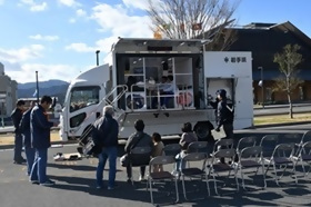写真：起震車で地震の揺れを体験する参加者の様子