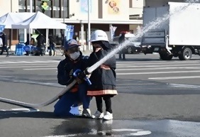 写真：子供が消防ホースを使って放水体験をしている様子