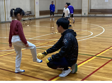 写真：ボールのけり方を指導する様子