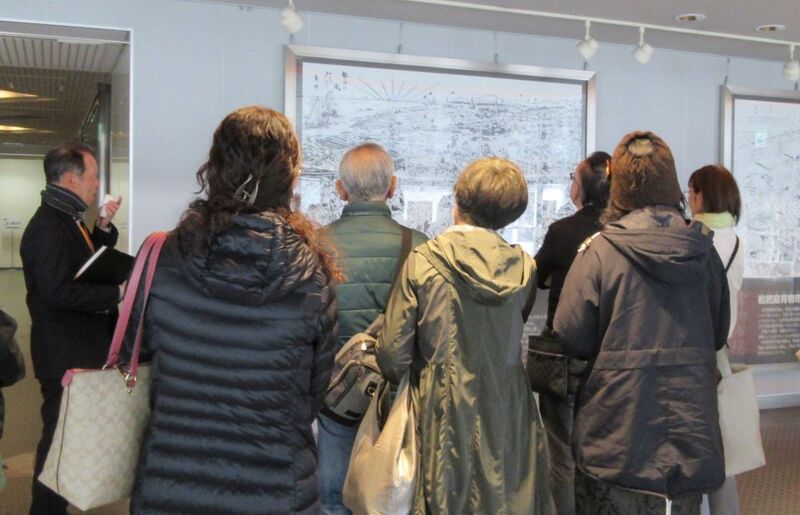 写真：パネルの前で説明を受けている様子