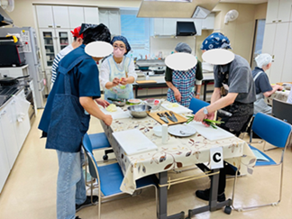 画像:サポートを受けながら調理する参加者の皆さん