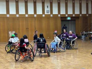 競技用車いすに乗る参加者たちの様子。紫色のシャツの二人はあいサポーター養成研修講師。