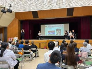 留学生3人がトークをする写真。スライドの文字：ウズベキスタンで人気のあるスポーツ