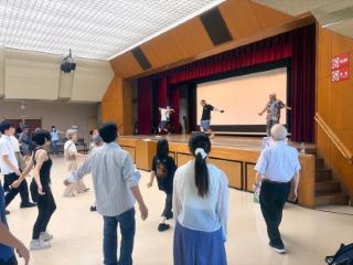 壇上のブレイキン協会の3人をマネして踊る参加者の写真