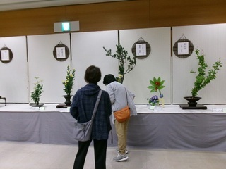 立ち止まっていけ花を眺める人の写真